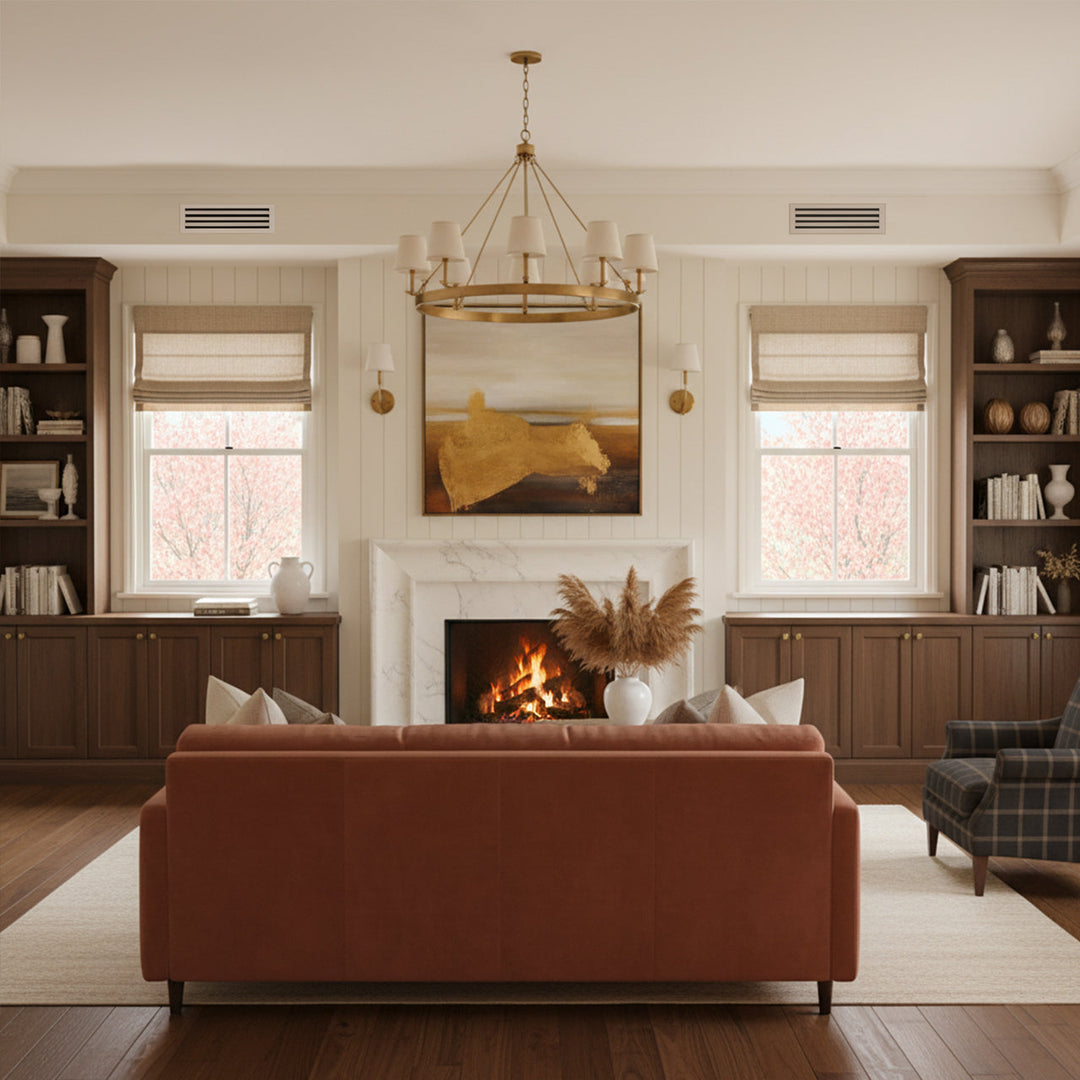 Cozy living room with fireplace at center flanked by windows and bookcases and leather couch in the foreground. Linear slot diffusers are above the windows. 
